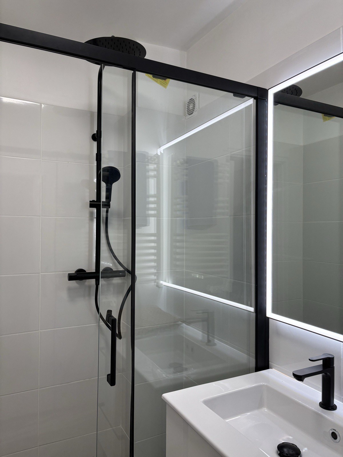 Salle de bain blanche & noire contemporaine, paroi de douche cadre noir, robinetterie mate — Marseille